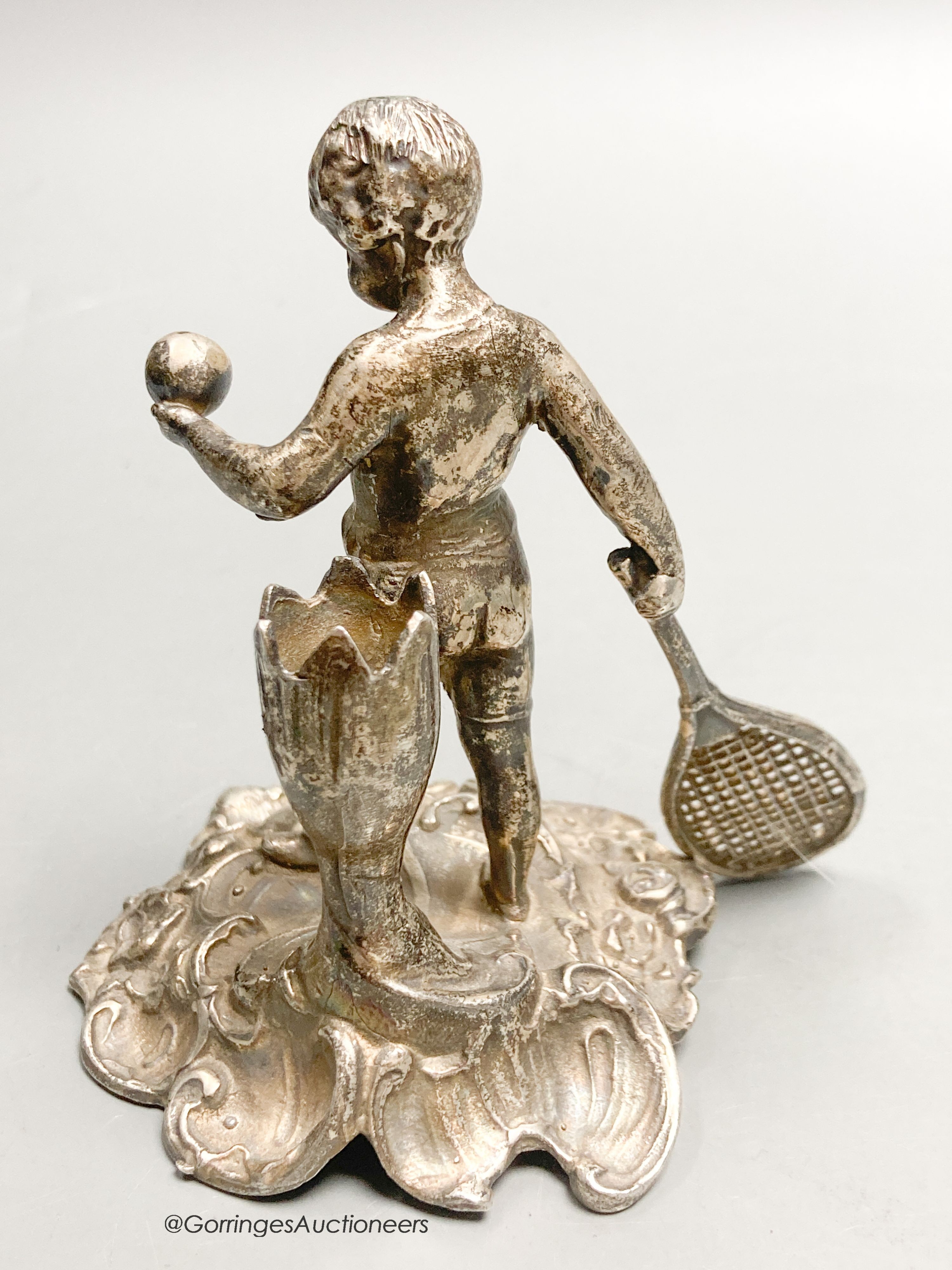 A French? white metal figural posy holder? modelled as a youth playing tennis, 9.1cm